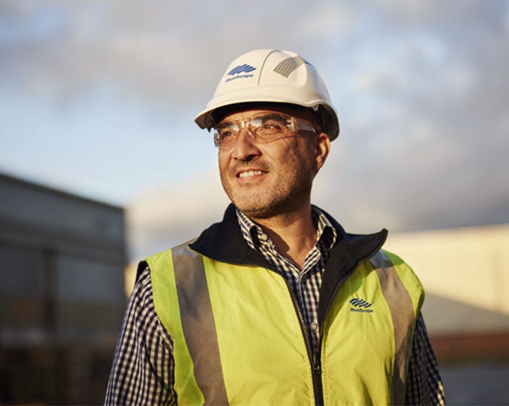 BlueScope worker in an outdoor setting wearing protective gear