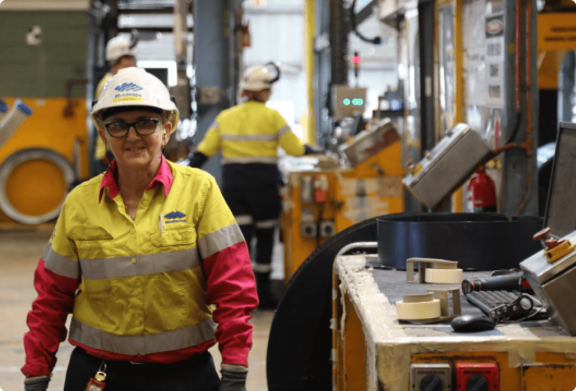 BlueScope employee walking past manufacturing workstation towards camera