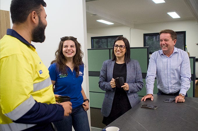 Four BlueScope employees gathered around a table talking