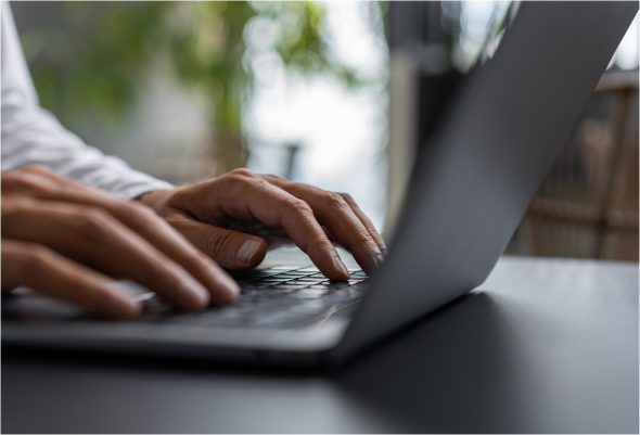 Typing on a laptop in an office