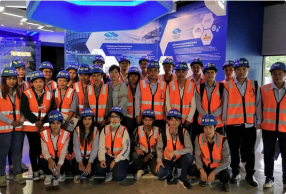 Large group of BlueScope employees in high-visibility clothing posing for a photograph during a conference