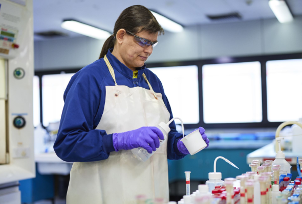 BlueScope employee in protective equipment measuring liquid in laboratory