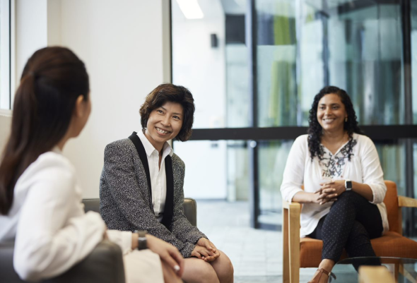 Three BlueScope employees sat in discussion in an office area